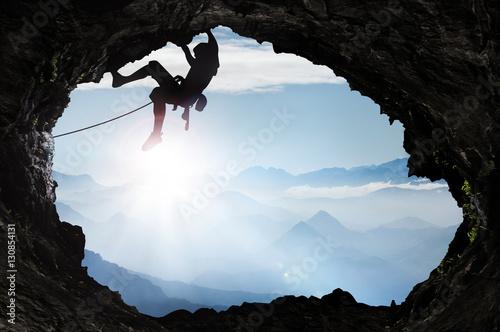 Mountaineer in the high mountains at a cave exit